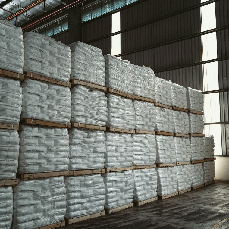 Sacks stacked in rows in a warehouse.