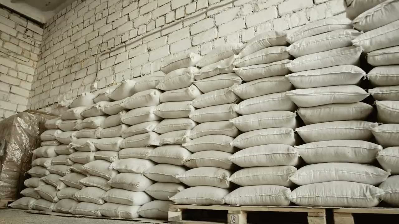 Closed sacks stacked on pallets in a warehouse.